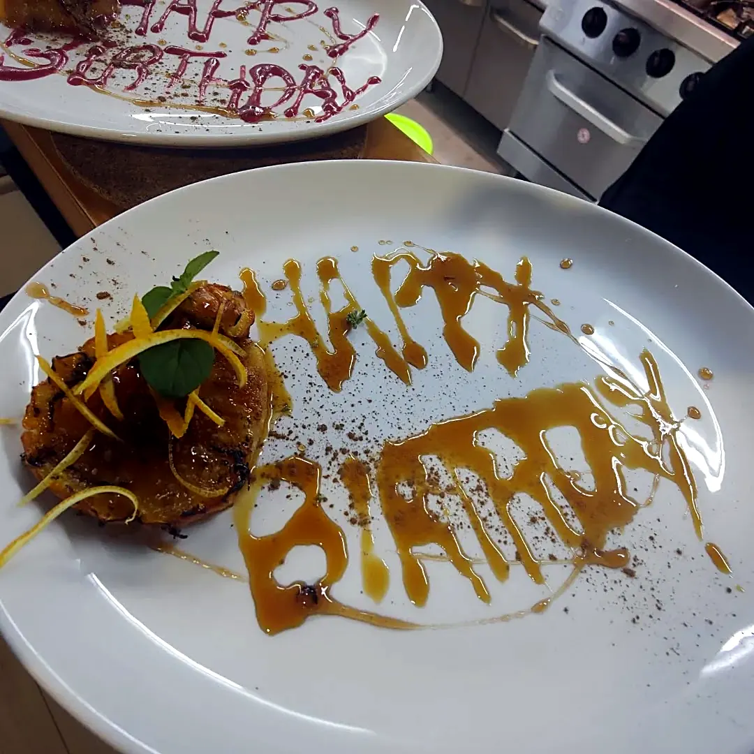 Geburtstagsdessert mit „Happy Birthday“ auf dem Teller, zu einem besonderen Anlass